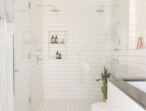 Badkamer die volledig halfsteensverband is betegeld met vierkante witte tegels