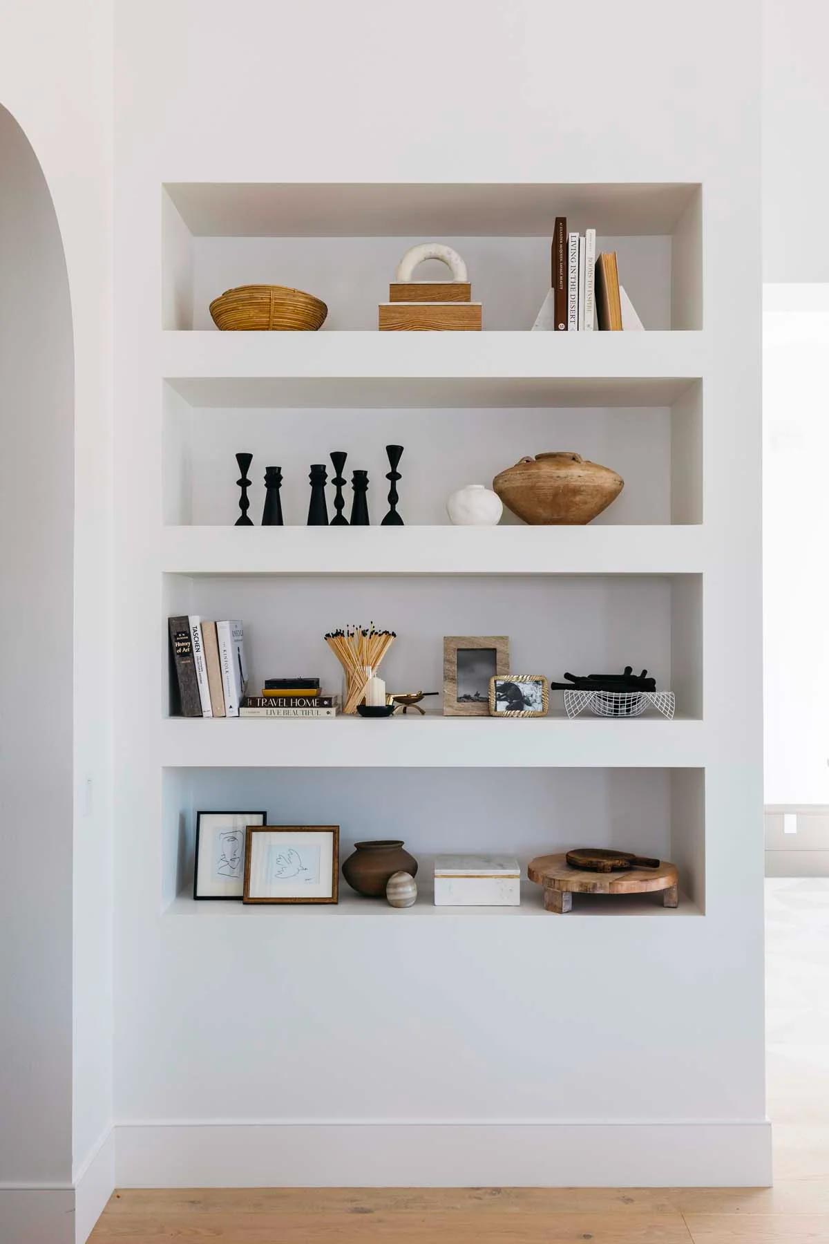 Een boekenkast met meerdere nissen boven elkaar in de muur | Bron: Thelifestyledco.com