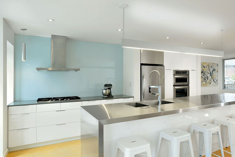 LineBox Studio koos voor deze moderne witte keuken voor een glazen keuken achterwand tot aan het plafond. LineBox Studio koos voor deze moderne witte keuken voor een glazen keuken achterwand tot aan het plafond.