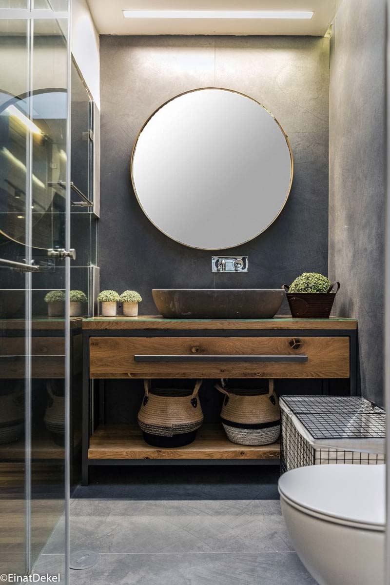 grote ronde spiegel boven industriele badkamermeubel