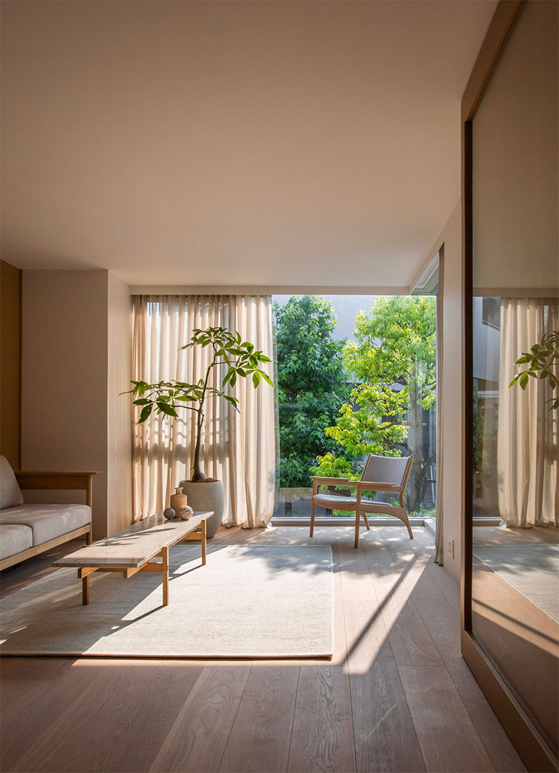 Betonlook muren, houten vloeren en eenvoudige meubels vormen "transparante" leefruimtes in dit paar voorheen licht uitgehongerde appartementen in Tokio, gerenoveerd door Norm Architects en Keiji Ashizawa Design.