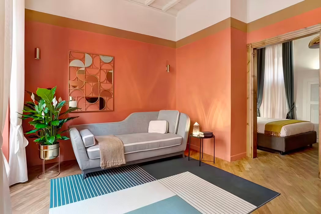 Studio Venturoni creeerde dit retro stijl interieur met een aantal mooie decoratie objecten. Het kunstwerk aan de muur boven de bank is daar een heel mooi voorbeeld van. | Fotografie: Michele Bonechi