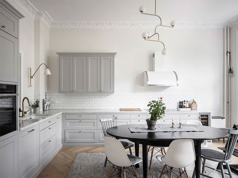 In deze chique klassieke keuken met lichtgrijze keukenkasten is de keuken achterwand betegeld met bijpassende witte metrotegels. In deze chique klassieke keuken met lichtgrijze keukenkasten is de keuken achterwand betegeld met bijpassende witte metrotegels.