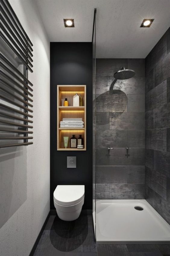 Een strakke maatkast met open planken boven het hangtoilet in deze kleine moderne badkamer.