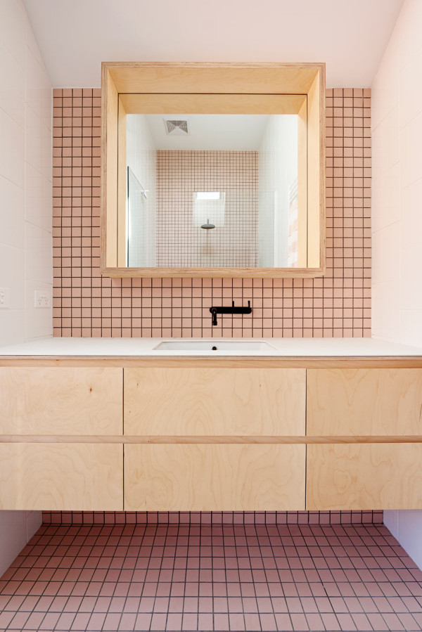 In deze kleine badkamer met roze tegels, is een grote zwevende badkamermeubel op maat gemaakt, die van muur tot muur loopt. Klik hier voor meer foto's.
