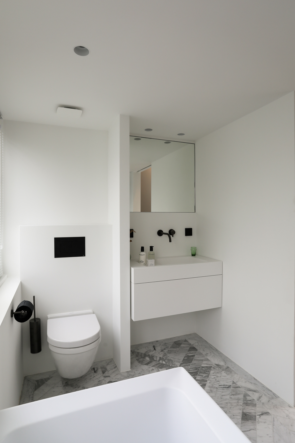 Een super mooie kleine badkamer met strakke muren en plafonds, waar trimless spots ingebouwd zijn. Klik hier voor meer foto's.
