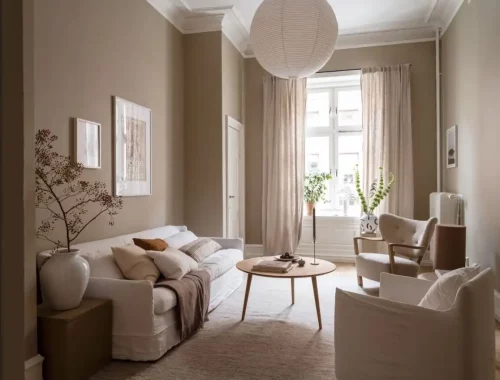 Deze mooie beige woonkamer kenmerkt zich door een mix van witte textielsoorten en zachte stofferingen, gecombineerd met enkele houtaccenten voor een ingetogen uitstraling.