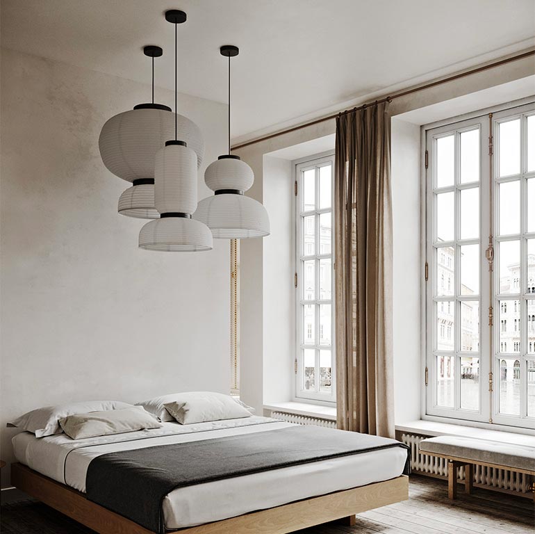 In deze slaapkamer schitteren de Formakami hanglampen van &Tradition in verschillende formaten aan het hoge plafond.