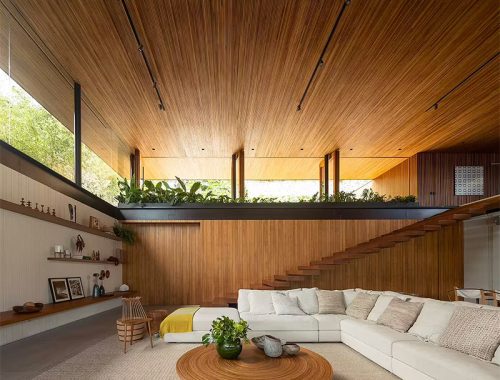 Deze prachtige luxe woonkamer is een ontwerp van Jacobsen Arquitetura - met zijn naadloze combinatie van staal, ruwe steen, natuurlijk hout en glas, biedt een ongeëvenaarde connectie met de zee en een comfortabele ruimte om vrienden en familie te ontvangen.