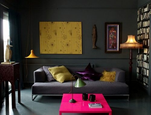 In deze woonkamer is bijna alles grijs, op een aantal gele accenten en een knalroze salontafel. Super stoer!
