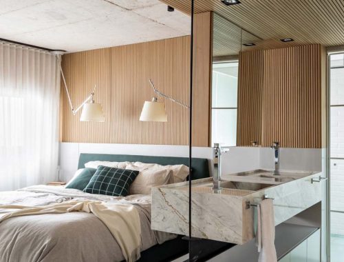 Architect Nildo José koos voor railverlichting in de slaapkamer, gecombineerd met strakke inbouwverlichting in het verlaagde en met hout beklede plafond in de badkamer en suite. Klik hier voor meer foto's.