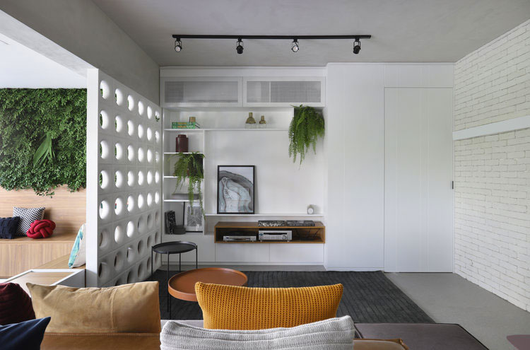 Als oplossing om een open indeling te creeeren, maar tóch verschillende ruimtes te hebben, koos Architect Elen Saravalli voor een moderne witte scheidingswand van Sintelblokken.