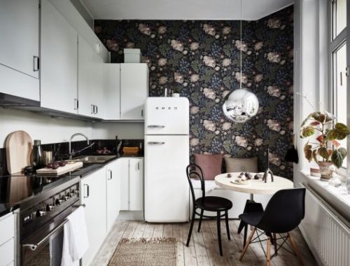 De muur bij de eethoek in deze fijne moderne keuken is een echte blikvanger geworden met het bloemetjesbehang.