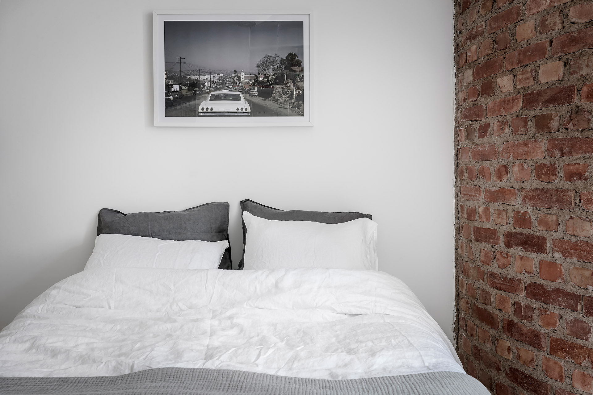 Deze witte slaapkamer is voorzien van een super charmante ronde bakstenen muur