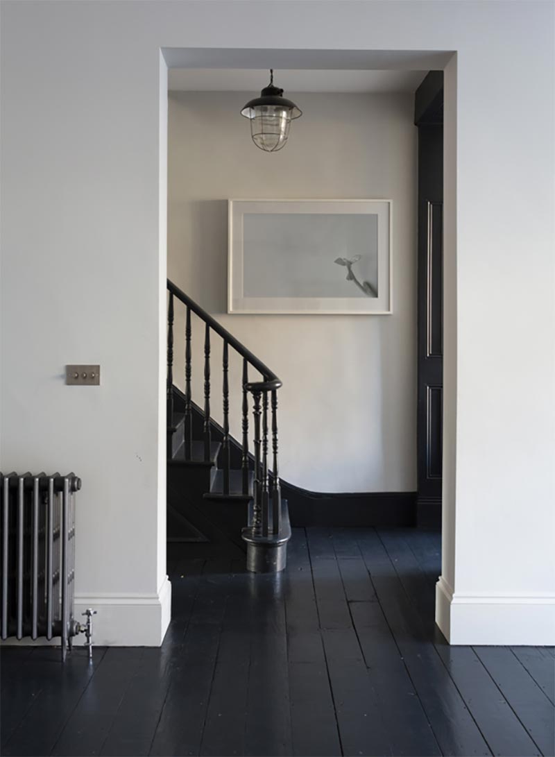 De zwart geverfde houten vloer loopt in deze klassieke hal prachtig over op de klassieke zwarte trap. | Bron: jjlocations.com