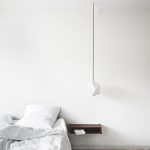 Een minimalistisch deisgn nachtkastje van hout in een minimalistische slaapkamer.